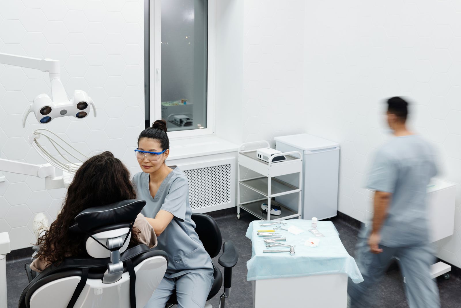 A dentist talks with a patient in a clinic. Illustrative stock photo, not Lincoln Dental staff or patients.