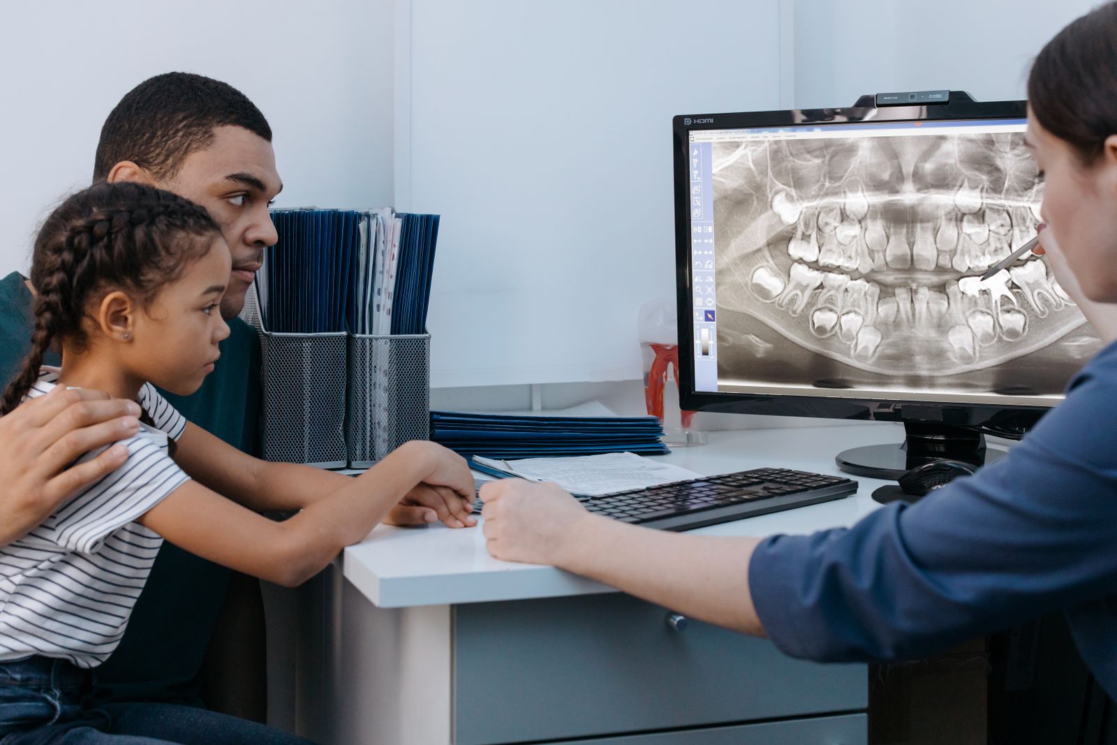A parent and child review a dental X-ray with a dentist. Pexels stock photo; illustrative, not Lincoln Dental staff or patients.